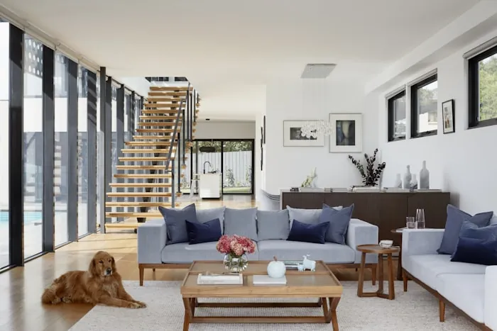 Living room lined with full-height glazing opening onto a terrace.